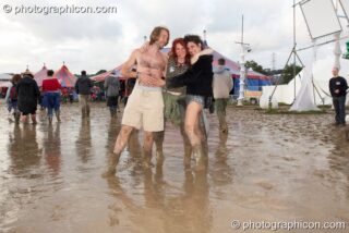 People walking in the mud in the Dance Village at Glastonbury Festival 2007. Pilton, United Kingdom. © 2007 Photographicon