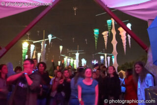 People dancing backdropped by haning decor in the ID Spiral area of the Dance Village at Glastonbury Festival 2007. Pilton, United Kingdom. © 2007 Photographicon