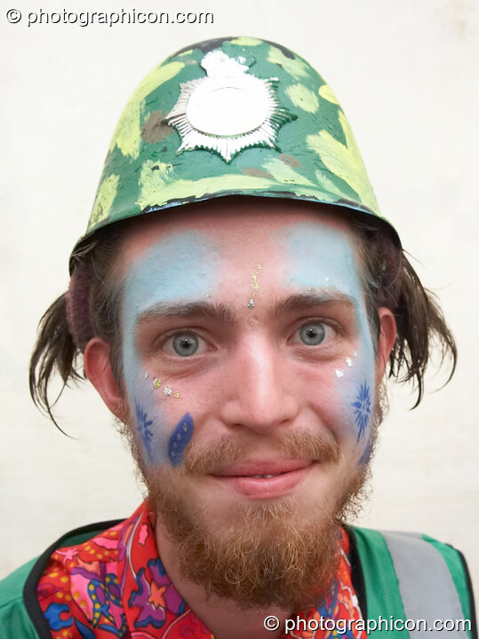 Portrait of a Green Police officer as they prepare their costume, with face painting by Simone & Natalie Kay, at Glastonbury Festival 2007. Pilton, United Kingdom. © 2007 Photographicon