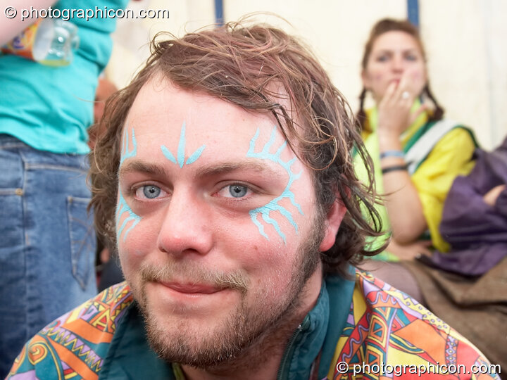 Portrait of a Green Police officer as they prepare their costume, with face painting by Simone & Natalie Kay, at Glastonbury Festival 2007. Pilton, United Kingdom. © 2007 Photographicon