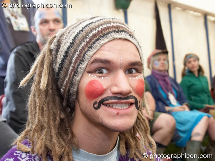 Portrait of a Green Police officer as they prepare their costume, with face painting by Simone & Natalie Kay, at Glastonbury Festival 2007. Pilton, United Kingdom. © 2007 Photographicon