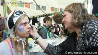 Portrait of a Green Police officer as they prepare their costume, with face painting by Simone Kay & her team, at Glastonbury Festival 2008. Pilton, United Kingdom. © 2008 Photographicon