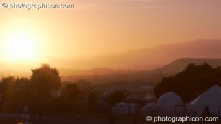 The sun sets over the Glastonbury Festival 2008 as observed from the south west part of the site. Pilton, United Kingdom. © 2008 Photographicon