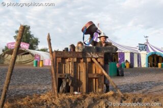 A group of friends jam on a wonky piano in the early morning mud at the Secret Garden Party 2007. Huntingdon, United Kingdom. © 2007 Photographicon