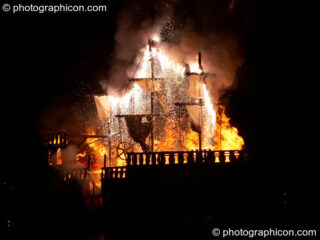 Fireworks erupt aboard the burning Galleon ship on the lake at the Secret Garden Party 2008. Huntingdon, United Kingdom. © 2008 Photographicon