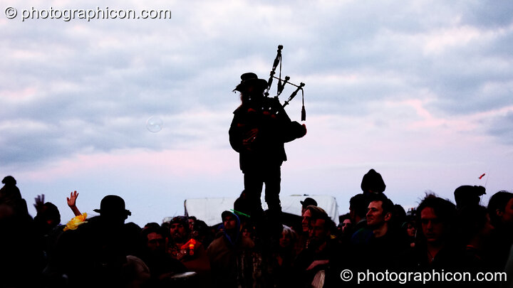 Standing on the Woodhenge, a piper calls the sun to rise for summer solstice at Sunrise Celebration 2006. Yeovil, United Kingdom. © 2006 Photographicon