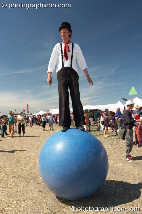 A man stands balanced on top of a large inflateable ball at Sunrise Celebration 2007. Yeovil, United Kingdom. © 2007 Photographicon