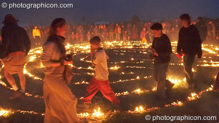 People walk the path through the blazing Green Dragon fire labyrinth at Sunrise Celebration 2007. Yeovil, United Kingdom. © 2007 Photographicon