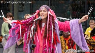 Ashera Hart resonates two tuning forks and sings in a performance with Drum4Africa, a fundraising project for African children, at the Thames Festival 2005. London, United Kingdom. © 2005 Photographicon