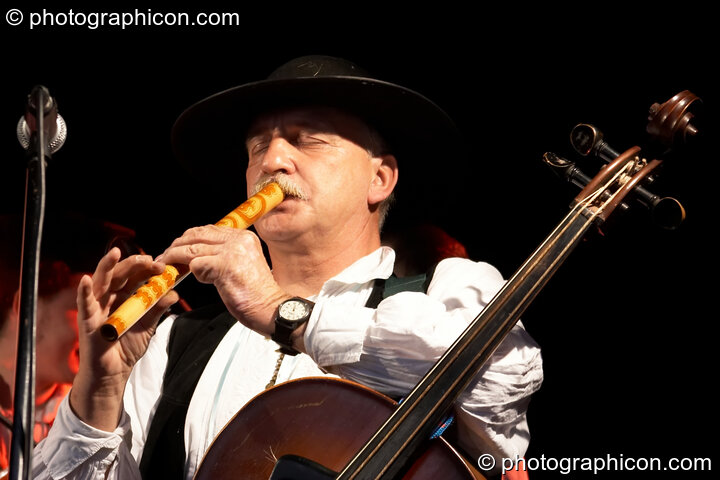 Musician plays recorder while wearing a double bass in Polish folk band Tatry at the Thames Festival 2005. London, United Kingdom. © 2005 Photographicon