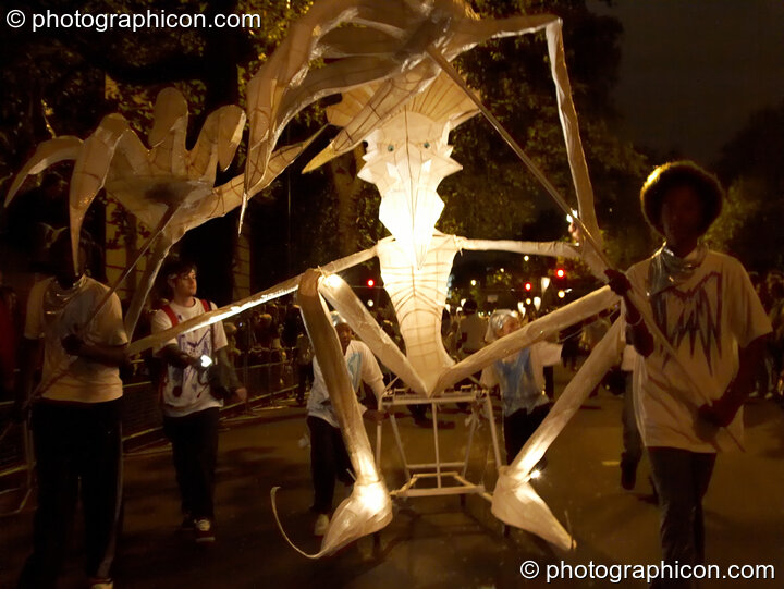 Internally illuminated carnival effigy of vaguely humanoid creature being wheeled by children at the Thames Festival 2005. London, United Kingdom. © 2005 Photographicon
