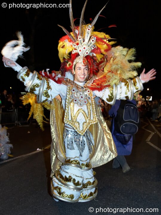 Man in colourful feathery costume finery dances participates in the carnival at the Thames Festival 2005. London, United Kingdom. © 2005 Photographicon