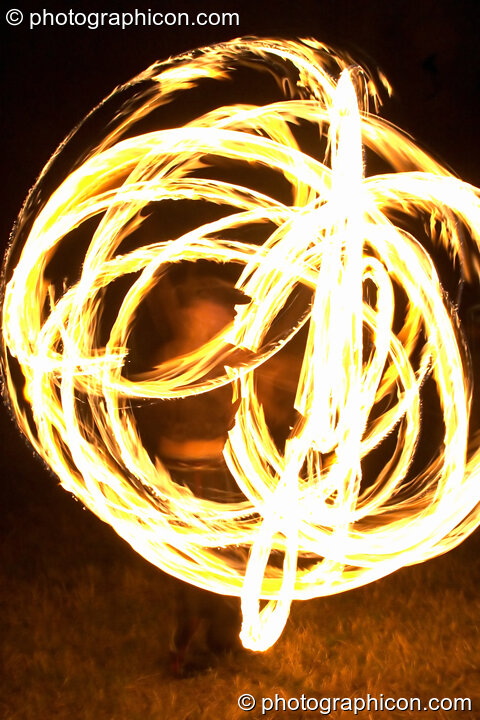 Fire sticks photographed at slow shutter speed to produce motion trails at the Turaya Gathering 2004. Wimborne, United Kingdom. © 2004 Photographicon