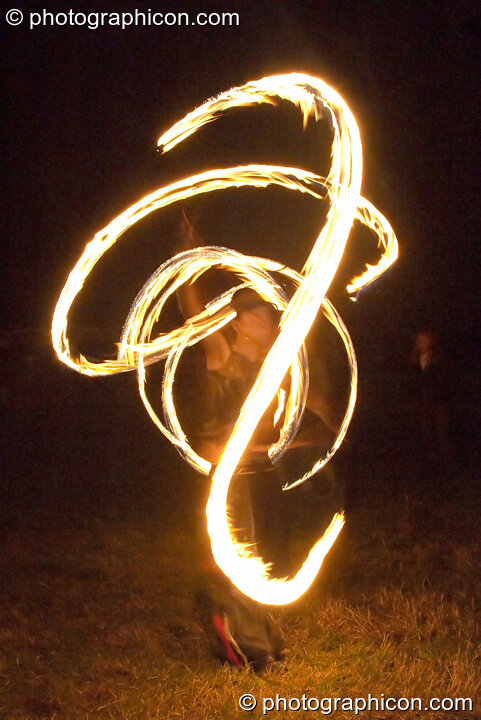 Fire sticks photographed at slow shutter speed to produce motion trails at the Turaya Gathering 2004. Wimborne, United Kingdom. © 2004 Photographicon