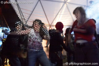 A woman lit by coloured spot projections dances in the Gaia Chill dome at Waveform Project 2007. Kenton, Exeter, United Kingdom. © 2007 Photographicon