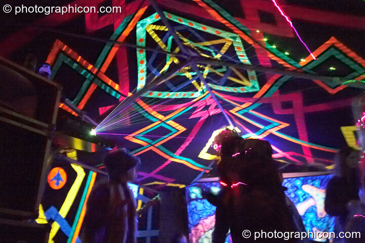 People dance amongst the lasers and decor in the Ninja Hippies tent at Waveform Project 2007. Kenton, Exeter, United Kingdom. © 2007 Photographicon