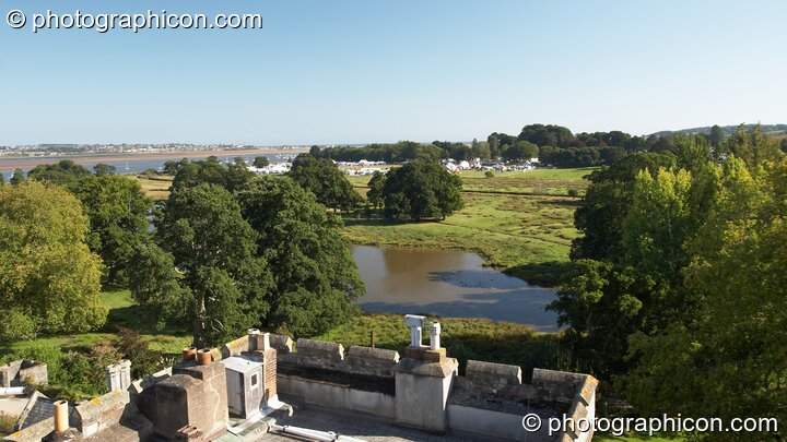 The Waveform Project 2007 festival site viewed from the roof of Powderham Castle's central flag tower, with lower roof-top and garden lake in the foreground, and the river Exe in the background. Kenton, Exeter, United Kingdom. © 2007 Photographicon