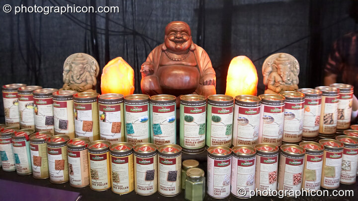 A wooden Buddha sits on top of a curved display of superfood tins inside the Chai Wallah cafe at Waveform Project 2007. Kenton, Exeter, United Kingdom. © 2007 Photographicon