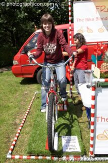 Woman on pedal powered smoothie maker at Kingston Green Fair 2006. Kingston upon Thames, United Kingdom. © 2006 Photographicon