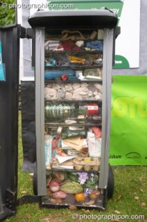 A cut-through of a domestic rubbish bin showing the types and amounts of recyclables it contains at the London Green Lifestyle Show 2005. London, United Kingdom. © 2005 Photographicon