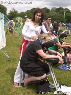 A woman gives a back massage at the London Green Lifestyle Show 2005. London, United Kingdom. © 2005 Photographicon
