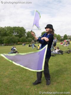 A man swinging flag like poi at the London Green Lifestyle Show 2005. London, United Kingdom. © 2005 Photographicon