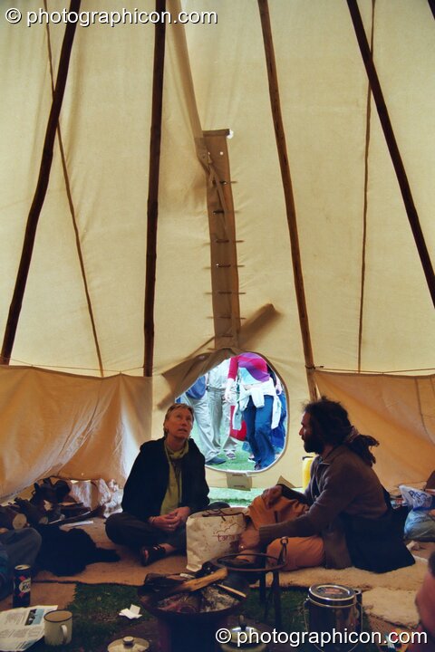 A shot from inside a wigwam of two men sitting in conversation at Kingston Green Fair 2002. Kingston upon Thames, United Kingdom. © 2002 Photographicon