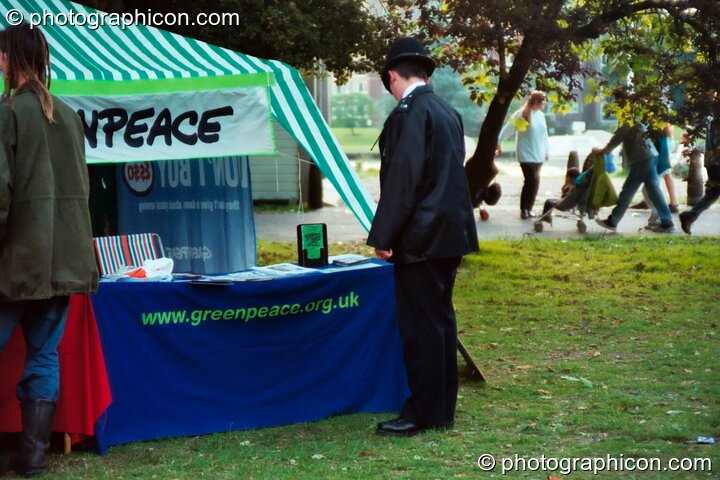 A policeman reading litrature on the Green Peace stall at Kingston Green Fair 2002. Kingston upon Thames, United Kingdom. © 2002 Photographicon