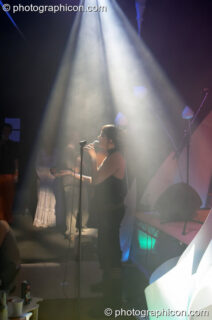 Woman vocalist illuminated by a downward cone of light in the Interdimensional Circus space at the Synergy Project. London, United Kingdom. © 2005 Photographicon