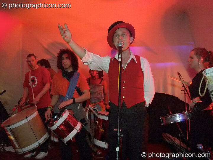 Man fronts a drumming band at The Synergy Project. London, United Kingdom. © 2005 Photographicon