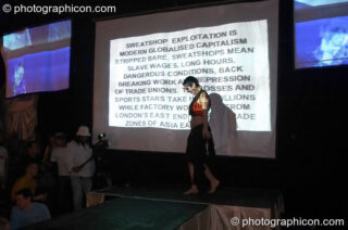 Woman stands in front of projected agitprop text at The Synergy Project. London, United Kingdom. © 2005 Photographicon