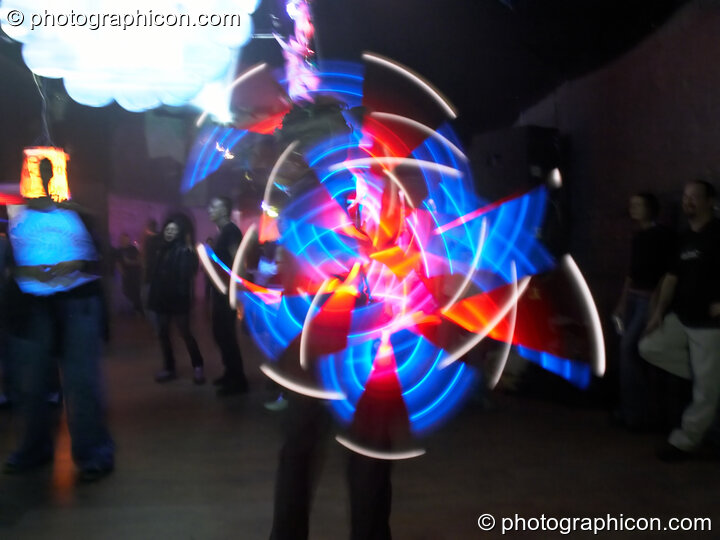 Jedi Juggler with illuminated flashing Glow Staffs, trail-blurred by slow shutter speed, at The Synergy Project. London, United Kingdom. © 2006 Photographicon