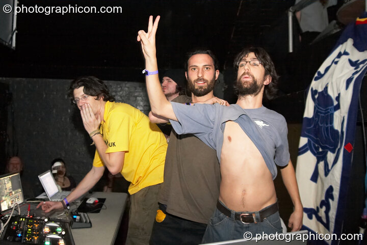 Roger, Ralph, and Calve of Inside-Us-All salute the audience while VJing at The Synergy Project. London, United Kingdom. © 2006 Photographicon