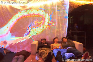 People chilling next to a dragon backdrop in the Kalahari room at The Synergy Project. London, United Kingdom. © 2007 Photographicon