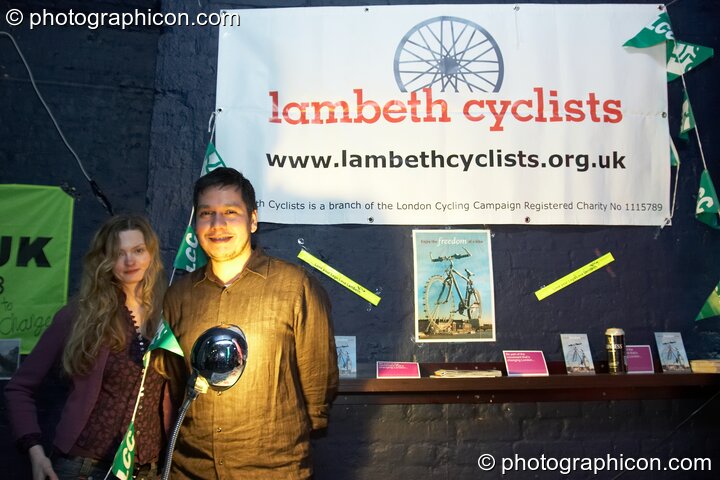 A man and woman stand by the Lambeth Cyclists stall in the Folktronica room at The Synergy Project. London, United Kingdom. © 2008 Photographicon