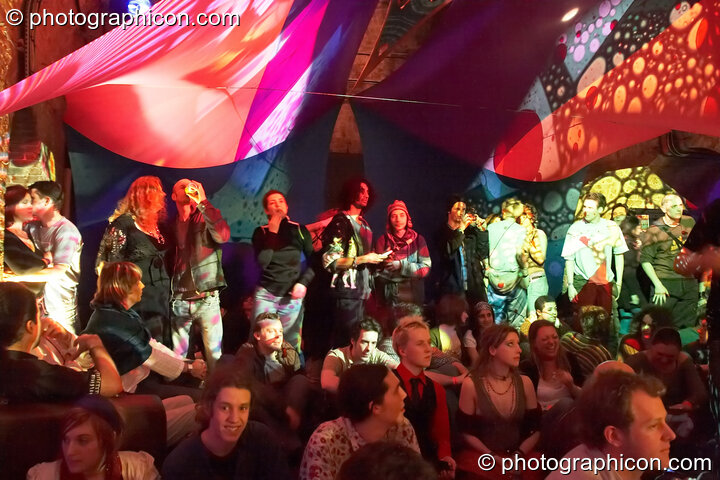 People chilling in the Inspiration Hall lit by coloured oil wheel projecions at The Synergy Project. London, United Kingdom. © 2008 Photographicon
