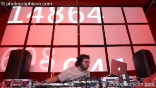 Justin Chaos (Point Red / Indica) DJs on the Future Music stage behind which is a projection screen by Inside Solutions at Luminopolis (formerly The Synergy Project). London, United Kingdom. © 2008 Photographicon