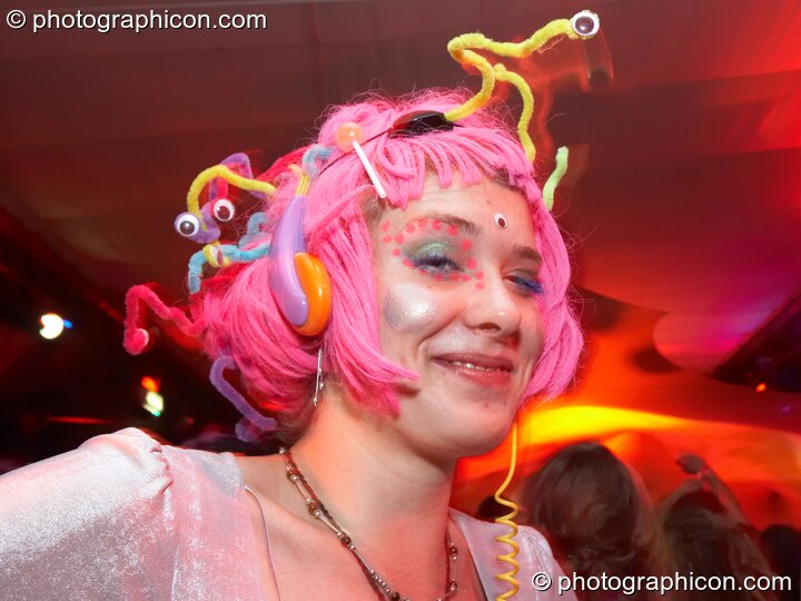 A woman wearing a pink decorated wig dances in the Small World room at Luminopolis (formerly The Synergy Project). London, United Kingdom. © 2008 Photographicon