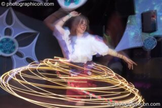A woman spins an illuminated Hula Hoop leaving a skirt-shaped light trail  in the Liquid Records room at Luminopolis (formerly The Synergy Project). London, United Kingdom. © 2008 Photographicon