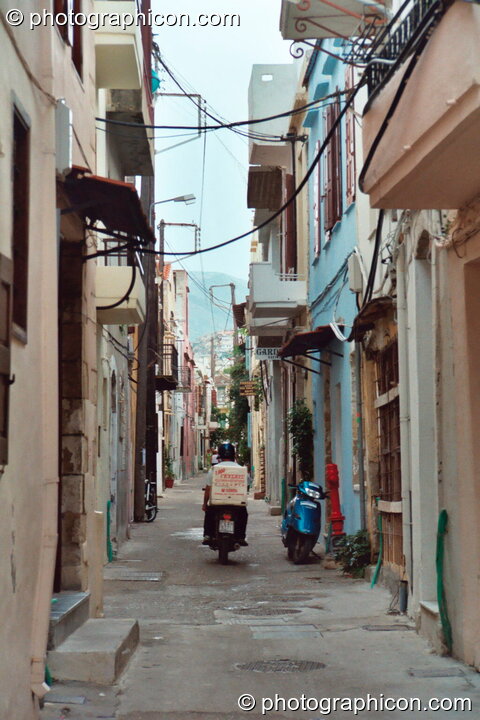 Man on scooter vanishes down a side street in Rethymno. Rethymno, Greece. © 2002 Photographicon