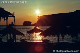 The golden sun sets over the beach and peninsula at Agios Pavlos. Agios Pavlos, Greece. © 2002 Photographicon