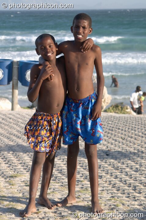 Two boys pose shoulder to shoulder on Mnandi Beach, Cape Town - Western Cape, South Africa. Cape Town, South Africa. © 2005 Photographicon
